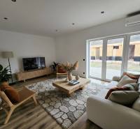 Obývací pokoj v rodinném domě s podlahou s dřevěným dekorem a elegantním nábytkem.