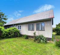 Rodinný dům v Novácích se zahradou, trávníkem a okrasnými keři.