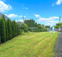 Zahradní plocha rodinného domu v Prievidzi s pečlivě udržovaným trávníkem a živým plotem.