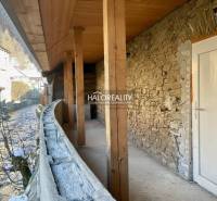 Přístřešek rodinného domu v Hronci s kamennou zdí a dřevěným stropem.