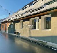 Rodinný dům v Hronci s pokrytím střechy sněhem a mokrou asfaltovou cestou.