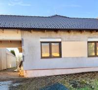 Rodinný dům v Cíferi s neomítnutou fasádou a hnědou střešní krytinou.