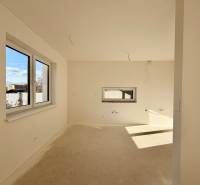 Interiér rodinného domu bez podlahy a s okny na slunečné straně.