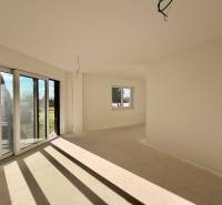 Prostorná místnost s velkými okny a výhledem v rodinném domě.