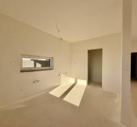 Prostorná nezařízená místnost v rodinném domě s oknem a dveřmi bez podlahy.