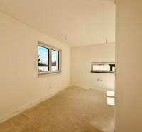 Prázdný pokoj s dvojitým oknem a betonovou podlahou v rodinném domě.