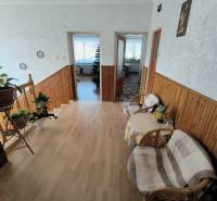 Interiér rodinného domu se schodištěm, podlahou s dřevěným dekorem a prostornou předsíní.