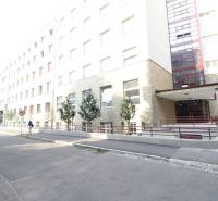 Budova na Bezručově ulici v Bratislavě - Starém Městě s rampou a stromy.