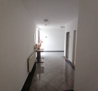 Chodba kanceláří s dlažbou a dekorací.