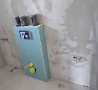 Nedokončená koupelna v rodinném domě s připravovanou instalací ve stěně.