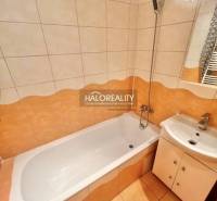 Koupelna ve 4-pokojovém bytě se sprchovací vanou a umyvadlem.