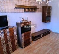 Obývací pokoj v 3-pokojovém bytě s televizí a podlahou s dřevěným dekorem.