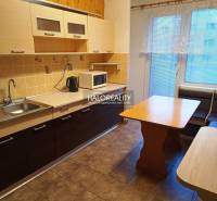 Kuchyně v 3-pokojovém bytě se světlými skříňkami, rohovou lavicí a podlahou s dřevěným dekorem.