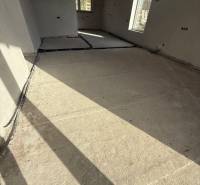 Interiér rodinného domu s betonovou podlahou a velkými okny z Mostu u Bratislavy.