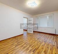 Prostorný pokoj s podlahou s dřevěným dekorem v 1-pokojovém bytě.