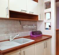 Kuchyňský kout v garsonce s dřezem a skříňkami.