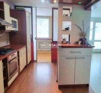 Kuchyně v garsonce s podlahou s dřevěným dekorem a světlým interiérem.