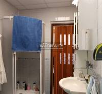 Koupelna se sprchovým koutem v chatě, vybavená umyvadlem a úložnými skříňkami.