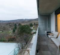 Balkon v 1-pokojovém bytě, výhled na přírodu, pohled na zahrady a stromy.