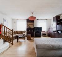 Obývací pokoj v rodinném domě s podlahou s dřevěným dekorem a pohodlným posezením.