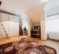 Pokoj v rodinném domě s podlahou s dřevěným dekorem, televizorem a skříní.