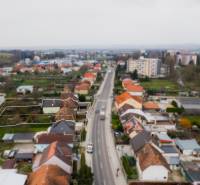 Rodinný dům na Partizánské ulici v Bánovcích nad Bebravou, lemovaný dalšími domy.