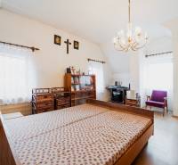 Ložnice v rodinném domě s podlahou s dřevěným dekorem, postelí a pracovním místem.