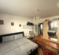 Ložnice s lustrem a skříní, podlaha s dřevěným dekorem v 3-pokojovém bytě.