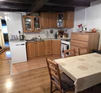 Kuchyně s dřevěným nábytkem a podlahou s dřevěným dekorem v rodinném domě.