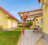 Zahrada u rodinného domu v Beši s terasou a udržovaným trávníkem.