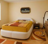 Ložnice s podlahou s dřevěným dekorem v rodinném domě, světlé stěny, moderní zařízení.