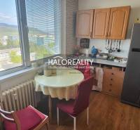 Kuchyně v 1-pokojovém bytě se stolem, židlemi a výhledem z okna.