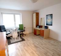 Pokoj s podlahou s dřevěným dekorem, pracovním stolem a křeslem v rodinném domě.