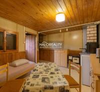 Interiér se stolem, židlemi a křeslem s látkovým potahem, podlaha s dřevěným dekorem.