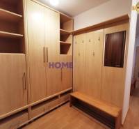 Vstupní hala ve 2-pokojovém bytě s nábytkem z dřevěného dekoru a zrcadlem.