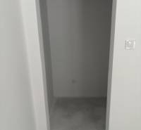 Úzké úložné prostory s betonovou podlahou v rodinném domě.