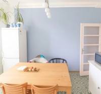 Jídelní kout v 3-pokojovém bytě s dřevěným stolem a designovou podlahou.