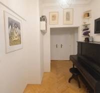 Chodba s klavírem a podlahou s dřevěným dekorem v 3-pokojovém bytě.