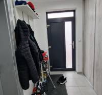 Vstupní hala rodinného domu, s dlažbou, věšákem a policí na obuv.