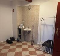 Interiér kanceláře s umyvadlem, věšákem a podlahou s dlažbou.