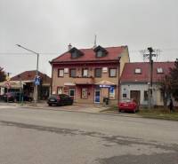 Budova s červenou střechou a obchody na Šafárikově ulici, Senec, vhodná pro kanceláře.