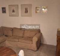 Obývací pokoj v 3pokojovém bytě s pohovkou, podlaha s dřevěným dekorem a dekoračními obrazy.