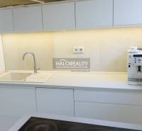 Kuchyně s bílými skříňkami a kávovarem ve 3-pokojovém bytě.