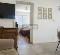 Obývací pokoj s televizí, židlemi a výhledem do ložnice ve 3-pokojovém bytě.