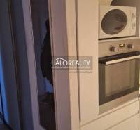 Interiér 3-pokojového bytu s podlahou s dřevěným dekorem a bílou komodou.