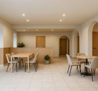 Jemně osvětlené obchodní prostory s oblouky, nábytkem a dlažbou, vytvářející příjemné prostředí.