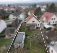 Rodinný dům na Nerudově ulici v Dubnici nad Váhom, zahrada, zpevněná cesta a okolní domy.