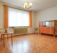 Obývací pokoj v rodinném domě s nábytkem a podlahou s dřevěným dekorem.