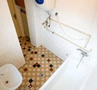 Koupelna s dlažbou a vanou v rodinném domě.