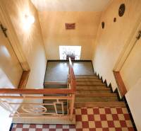 Schodiště s dřevěným zábradlím a podlahou s dřevěným dekorem v rodinném domě.